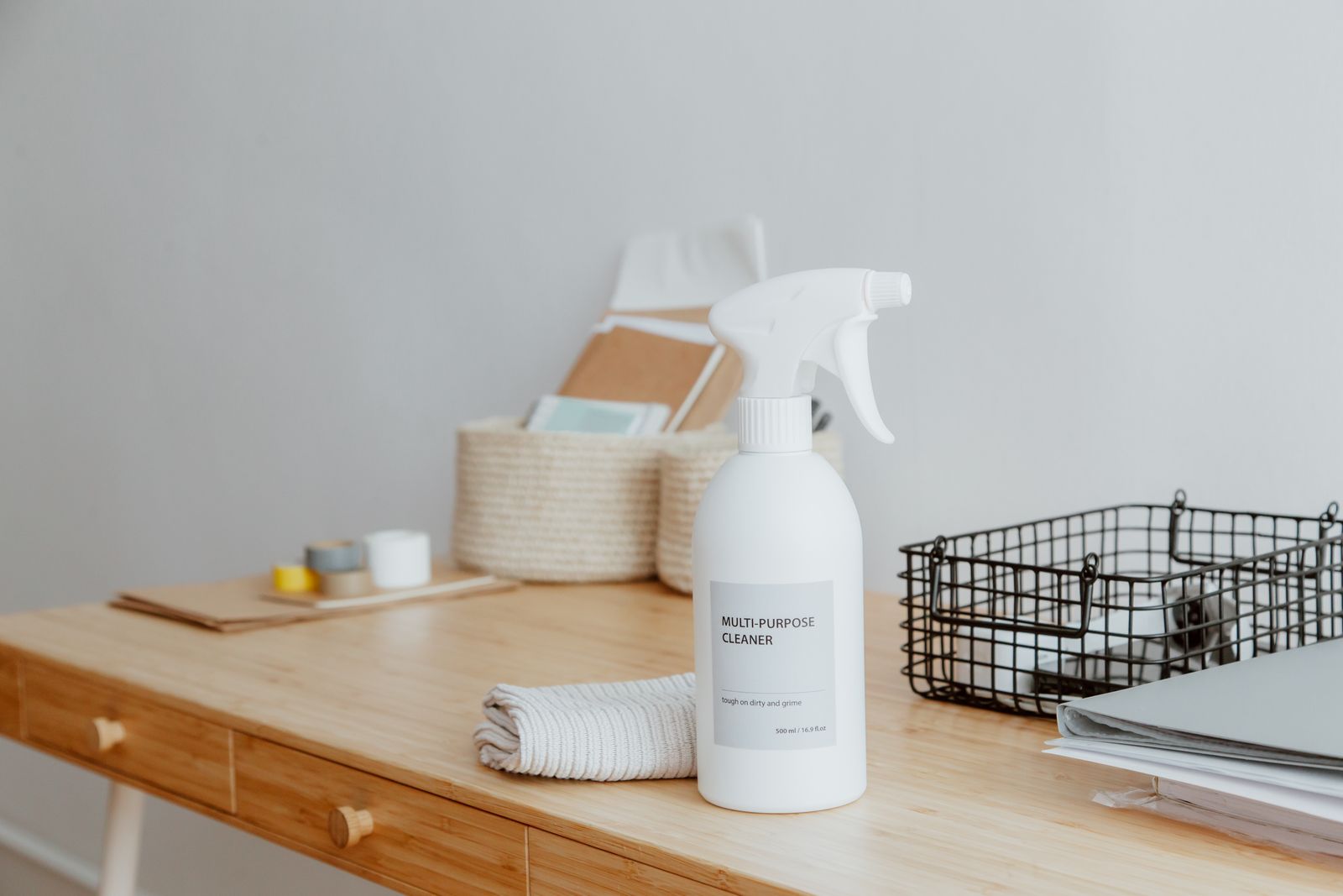 Multi-purpose cleaner and folded cloth on a freshly wiped office desk