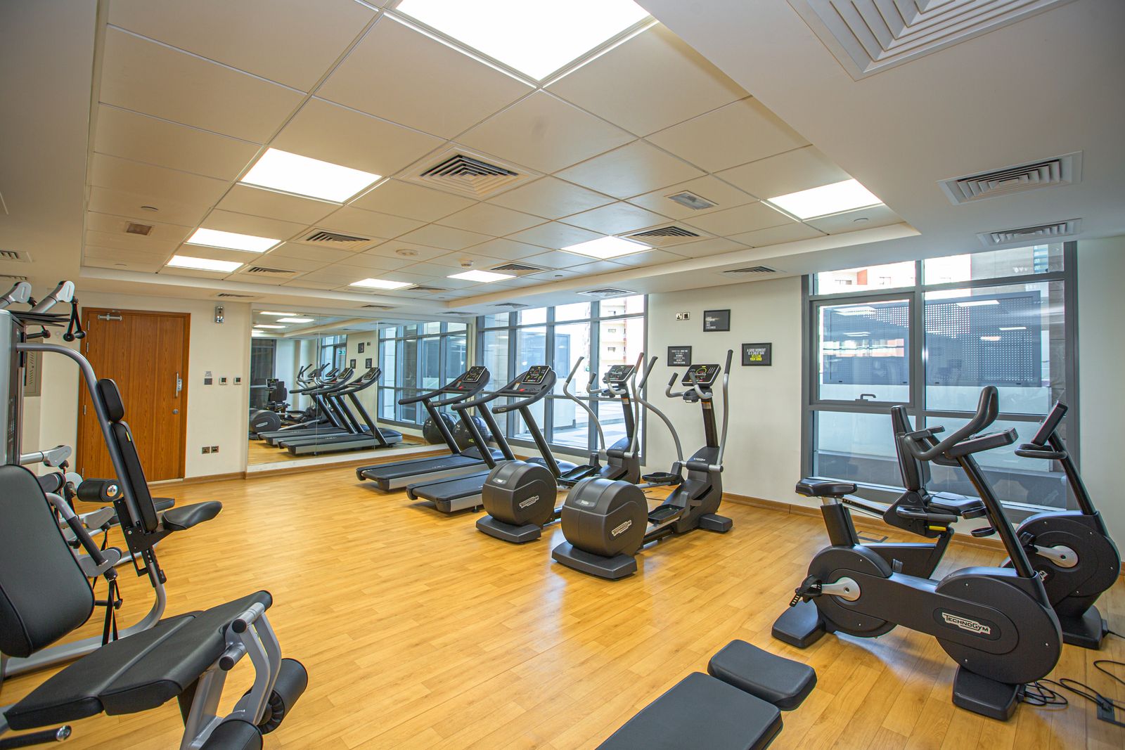 Spacious indoor commercial gym floor with clean equipment and polished surfaces