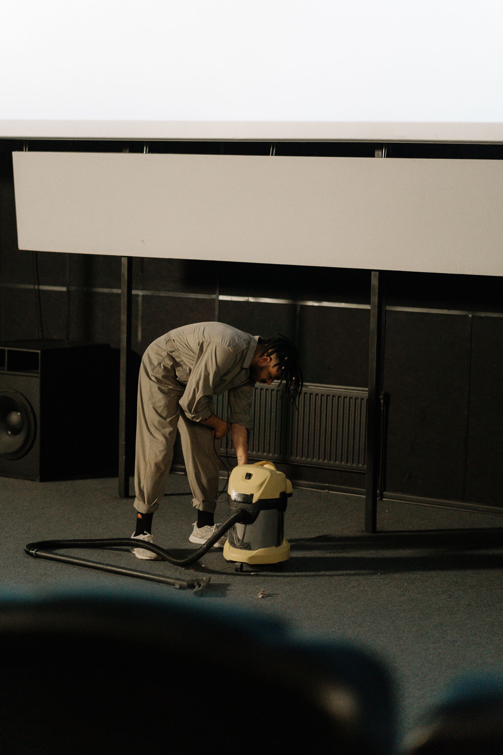 Technician deep-cleaning commercial carpet in a theater with a hot-water extraction machine